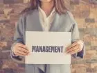 Praca po zarządzaniu - kobieta trzymająca kartkę z napisem management