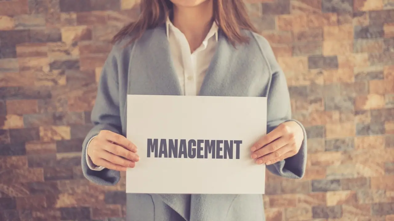 Praca po zarządzaniu - kobieta trzymająca kartkę z napisem management