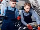 Elektryk samochodowy - mechanicy elektrycy przy samochodzie z laptopem