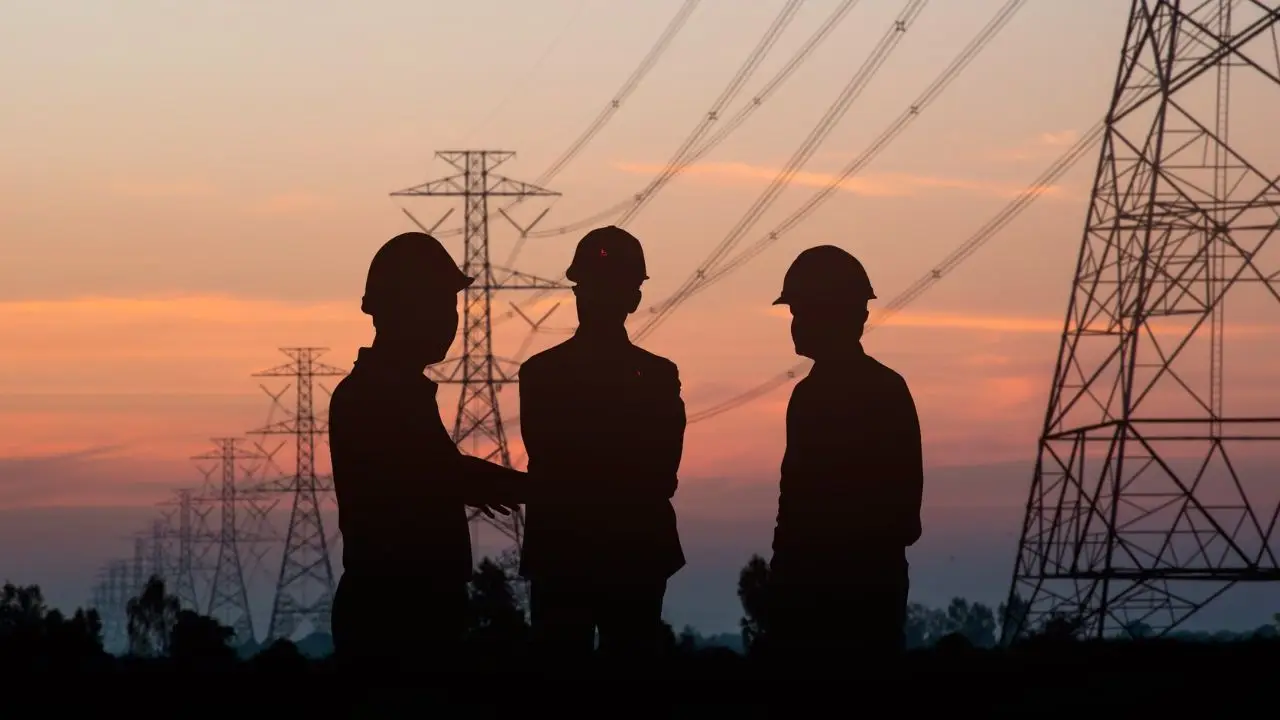 Energetyka - sylwetki ludzi pracujących przy słupach energetycznych