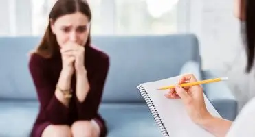 Jak zostać psychiatrą - pacjentka w gabinecie lekarza psychiatry prowadzącego notatki