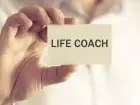 Life coach - osoba trzymająca w dłoni plakietkę z napisem life coach
