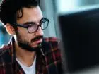 Analityk IT - mężczyzna w okularach przed komputerem