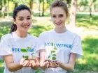 Jak zostać wolontariuszem - dwie wolontariuszki w drzewkami w dłoniach