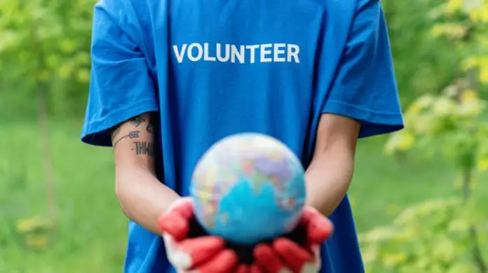 Jak zostać wolontariuszem za granicą - wolontariusz trzymający globus