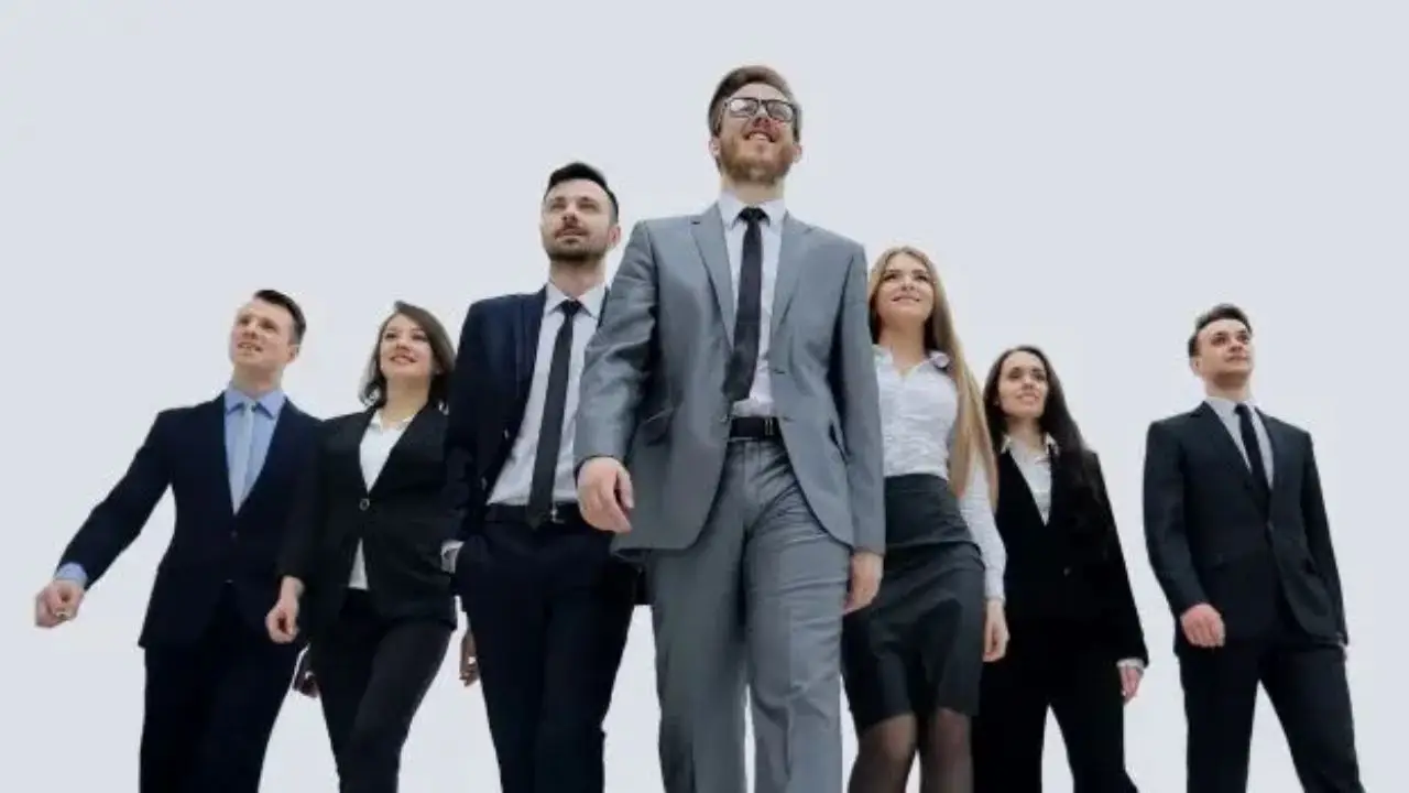Elegancko ubrani ludzie, idący za liderem