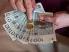 najniższa emerytura w 2023 - pieniądze trzymane w dłoniach starszej osoby