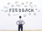 Opinie klientów - pracodawca patrzący na grafikę na ścianie z napisem feedback