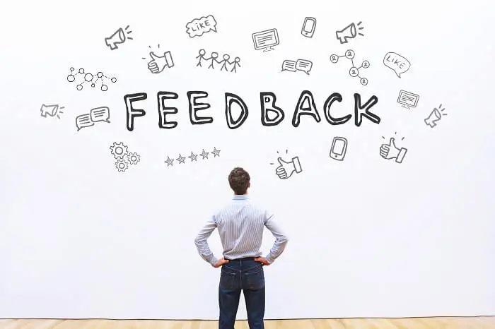Opinie klientów - pracodawca patrzący na grafikę na ścianie z napisem feedback