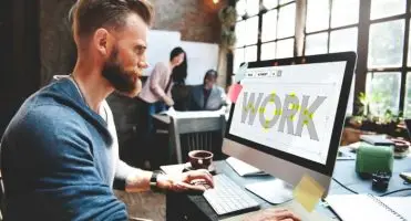 Mężczyzna pracujący przy komputerze z napisem "work" na ekranie