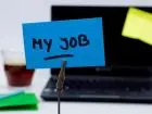 Kartka z napisem "my job" na tle laptopa