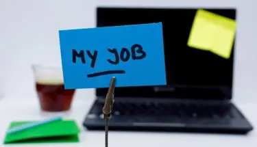 Kartka z napisem "my job" na tle laptopa