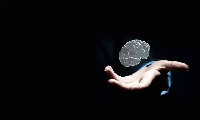 Psychiatra - grafika ludzkiego mózgu w dłoni na ciemnym tle