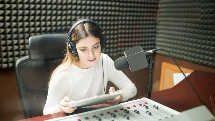 Jak zostać lektorem radiowym - kobieta w studiu radiowym mówiąca do mikrofonu