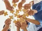 Co składa się na kulturę organizacyjną - pracownicy trzymający puzzle