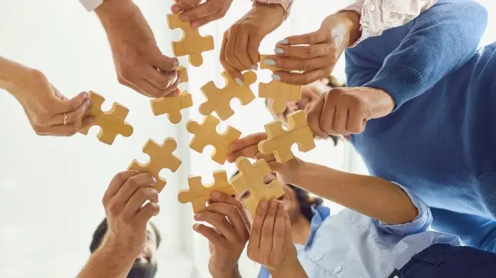Co składa się na kulturę organizacyjną - pracownicy trzymający puzzle