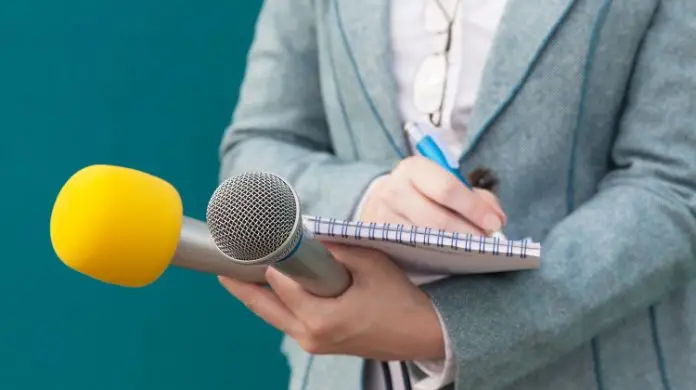 Jak kształtować PR przedsiębiorstwa - kobieta trzymająca mikrofony i notatnik