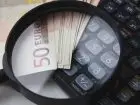 ZUS po 2 latach działalności - kalkulator, lupa, banknoty