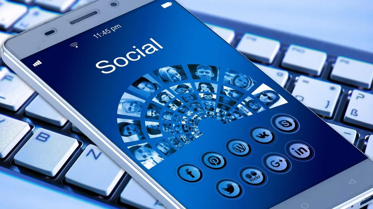 Masowe zwolnienia Facebook - napis social na ekranie telefonu