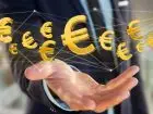 Na co mozna pozyskać fundusze unijne? Mężczyzna wyciagający dłoń w stronę znaków waluty euro