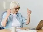 Ciesząca się seniorka przed laptopem