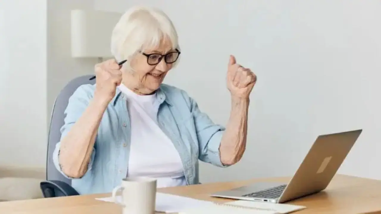 Ciesząca się seniorka przed laptopem