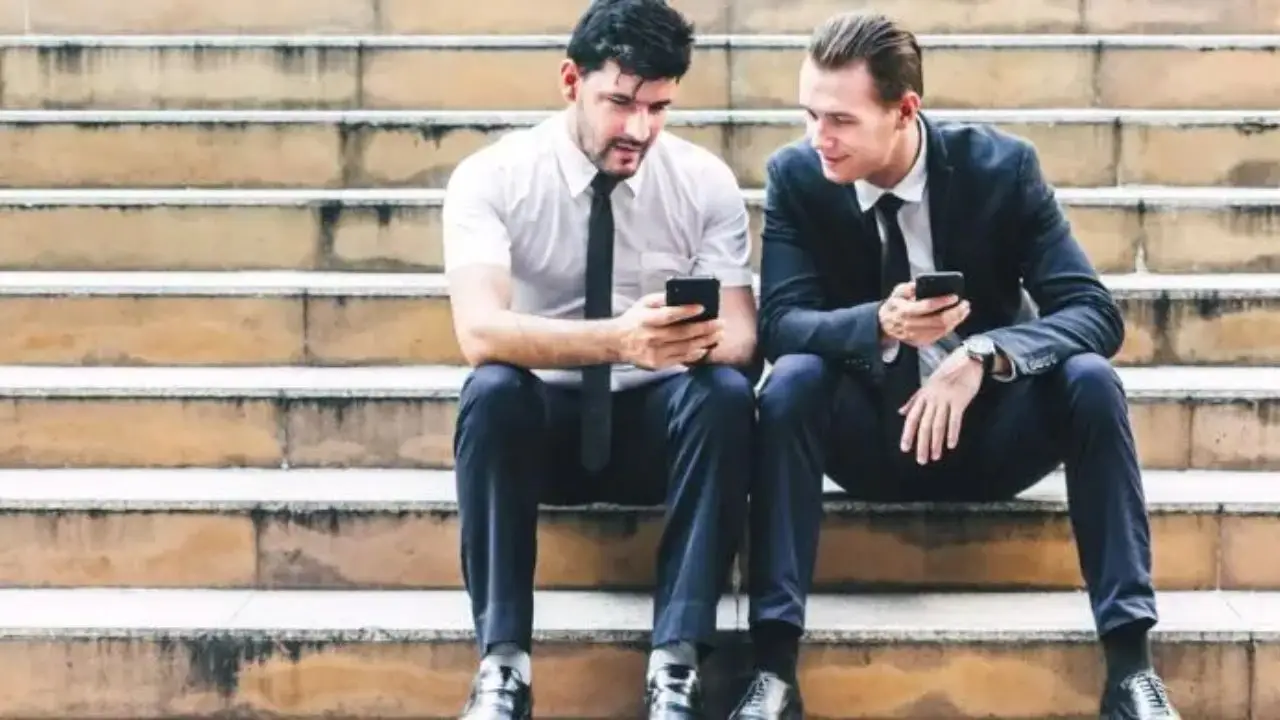 Jak założyć spółkę z.o.o. krok po kroku - dwóch, elegancko ubranych mężczyzn siedzących na schodach