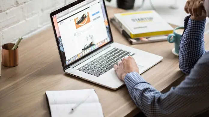 Mężczyzna przeglądający stronę internetową na laptopie
