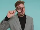 Elegancko ubrany mężczyzna patrzący przez lupę