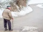 Emeryt na ulicy na spacerze o lasce