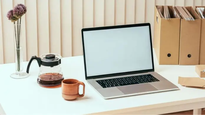 Otwarty laptop i kawa na biurku