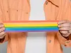 Kampania transpraca.pl - symboliczne zdjęcie przedstawiające osobę trzymającą flagę LGBT