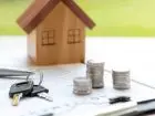 Wakacje kredytowe przedłużone 2024 - klucze od domu, figurka domu, monety i umowa położone na stole