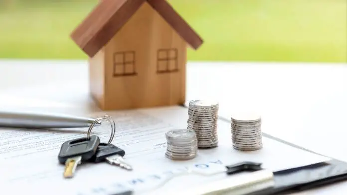 Wakacje kredytowe przedłużone 2024 - klucze od domu, figurka domu, monety i umowa położone na stole