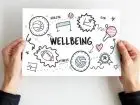 Wellbeing - kartka z napisem "wellbeing" i rysunkami wskazującymi na różne formy aktywności