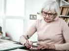Kobieta w wieku emerytalnym siedząca przy biurku