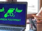 Laptop z napisem na ekranie dotyczącym śladu węglowego - praca zdalna a ślad węglowy
