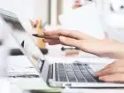 Dłuższa praca urzędów - dłoń pracownika urzędu wskazująca na ekran komputera