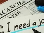 Bezrobocie w Polsce - prasa z napisem i need a job