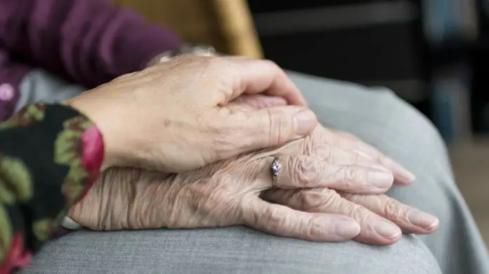 Bon senioralny - zdjęcie przedstawiające dłoń seniorki i wsparcie w postaci dłoni drugiej osoby