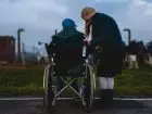 9460 świadczenia wspierającego - symbolcizne zdjęcie rpzedstawiające opiekuna z osobą z niepełnosprawnością na wózku