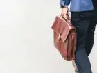 Grupowe zwolnienia w firmie w Krakowie - symboliczne zdjęcie przedstawiające mężczyznę w garniturze z walizką