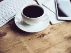 Przerwa w pracy - ile na 8 h - kawa i telefon obok laptopa na biurku