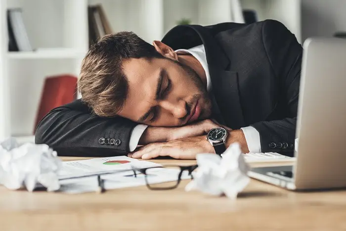 Chronotyp snu - śpiący pracownik w biurze