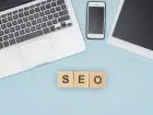 Co to są usługi SEO - ułożony napis z klocków (SEO). W tle urządzenia mobilne