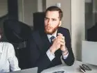 Jak przekonać szefa do siebie - elegancki mężczyzna siedzący przy biurku