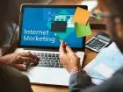 Jak zadbać o marketing internetowy firmy - dwie osoby siedzące przy laptopie z napisem "Internet marketing" na ekranie
