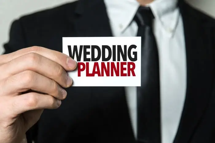 Mężczyzna trzymający wizytówkę z napisem wedding planner