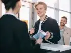 Mężczyzna przekazujący dokumenty elegancko ubranej kobiecie