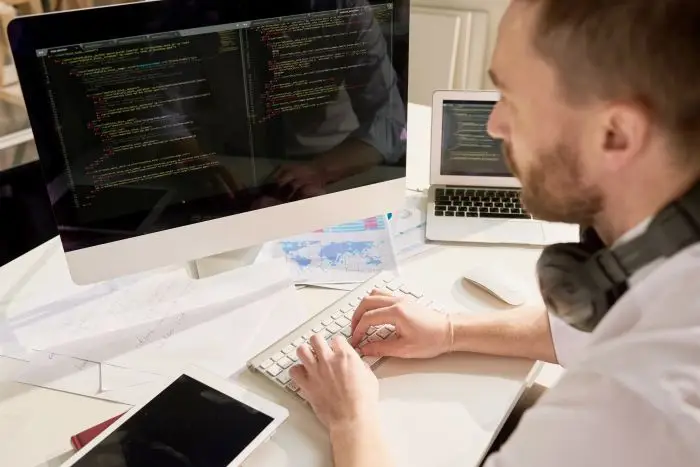 Jak znaleźć peirwszą pracę w IT - mężczyzna pracujący przy komputerze